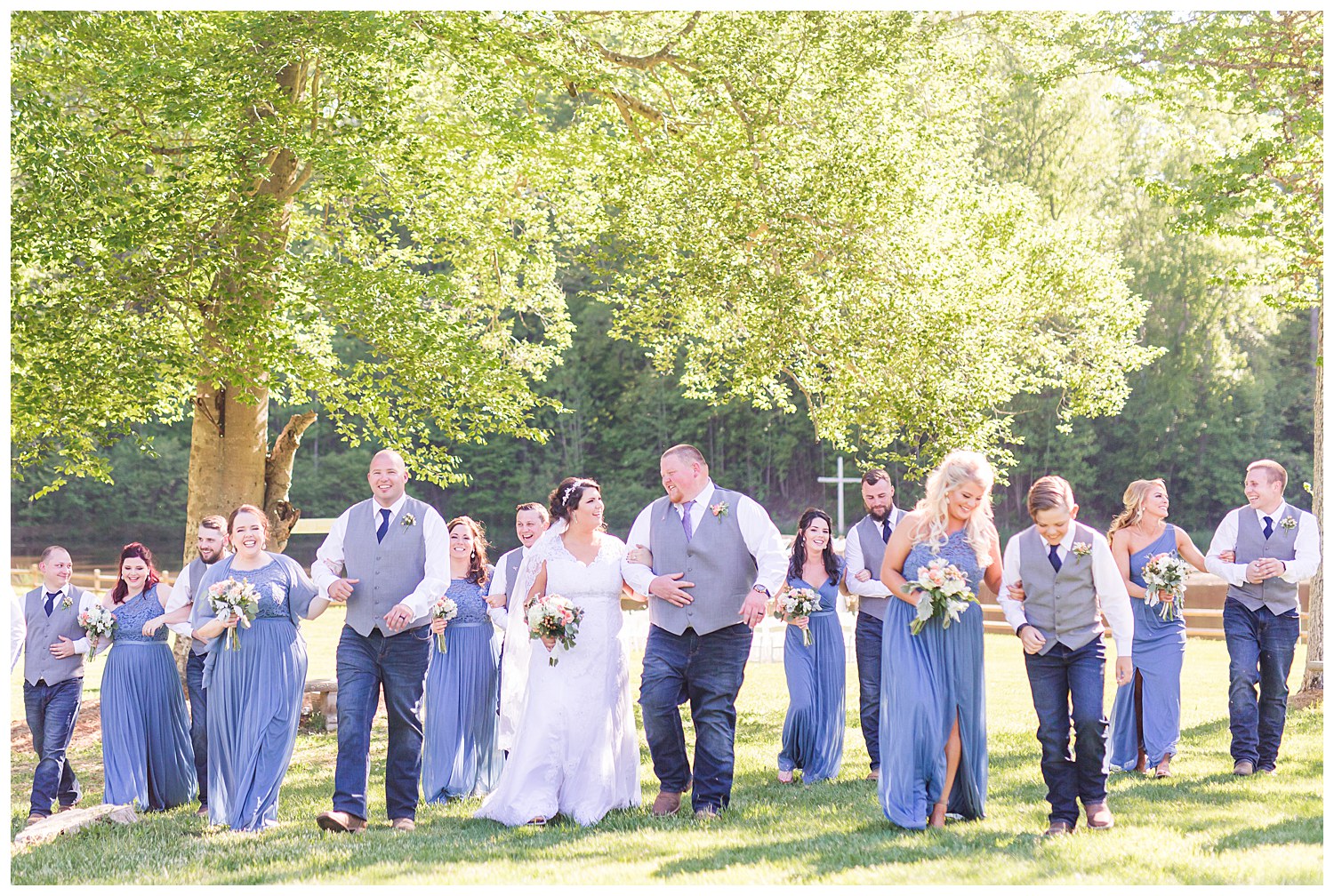 Wedding party with dusty blue bridesmaids dresses and groomsmen in jeans rustic wedding in Charlotte NC