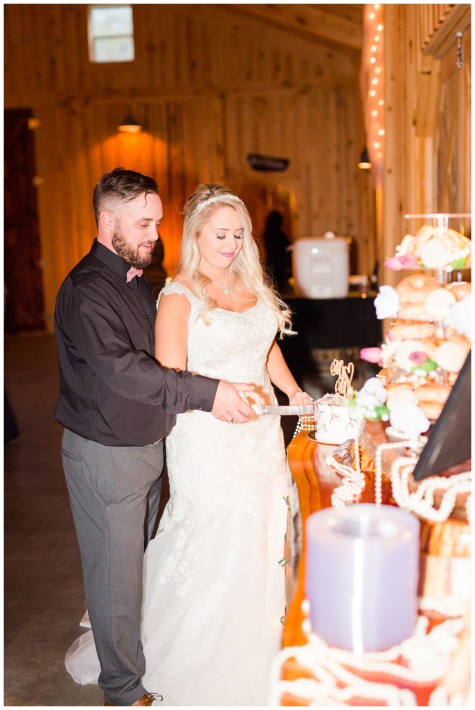 Bride and groom cutting wedding cake at the Shed at Quiet Hollow in Maiden, NC by Charlotte wedding photographer, Jacqueline Jones