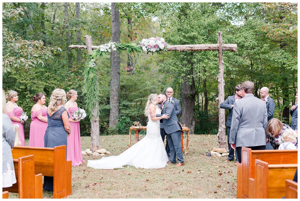 Bride and groom kissing at the alter at the Shed at Quiet Hollow in Maiden, NC by Charlotte wedding photographer, Jacqueline Jones