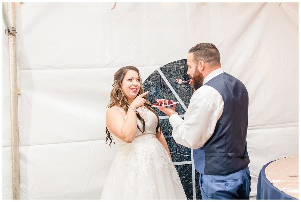 Bride and groom eating cake in Morganton, NC at Double C’s Acres by Charlotte wedding photographer, Jacqueline Jones