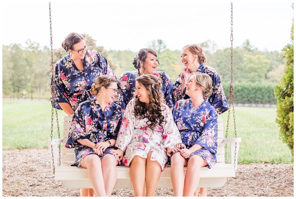 Bride and bridesmaids on swing in Morganton, NC at Double C’s Acres by Charlotte wedding photographer, Jacqueline Jones