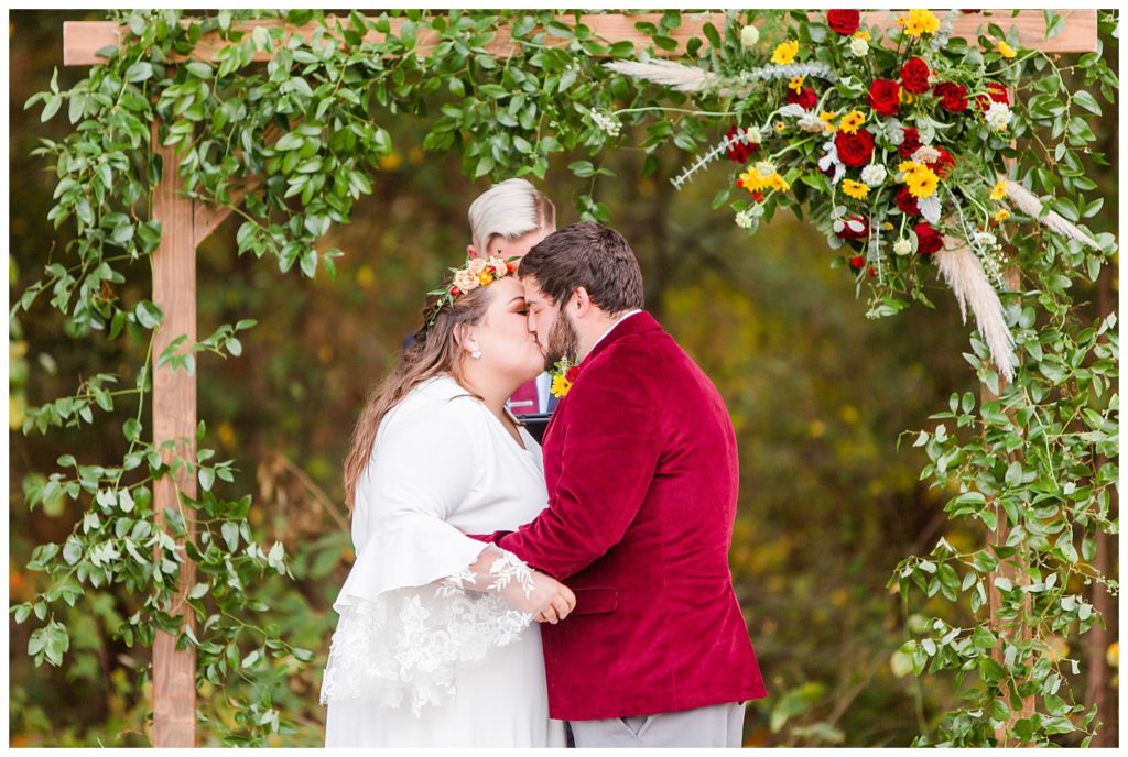 Bride and groom kissing at alter at Circle M Farm in Lincolnton, NC by Charlotte wedding photographer, Jaqueline Jones