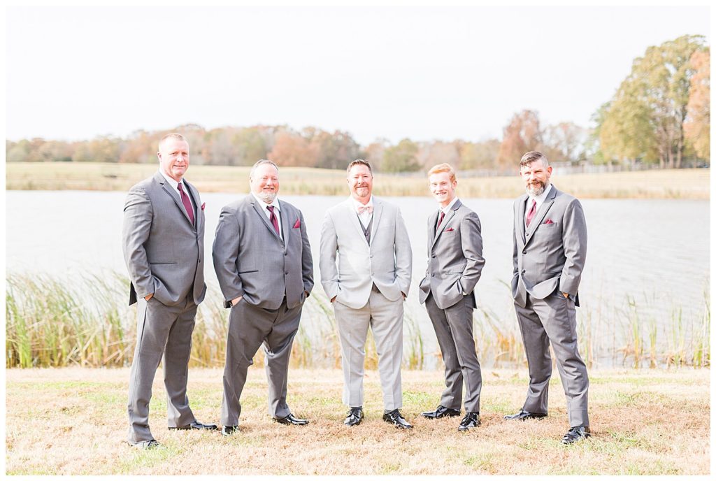 Groomsmen by lake at NC wedding in Mount Pleasant at the Farm at Brusharbor by Charlotte wedding photographer, Jacqueline Jones