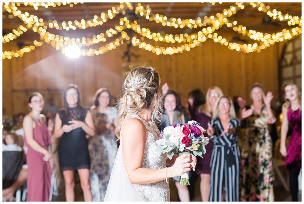 Bride throwing bouquet at NC wedding in Mount Pleasant at the Farm at Brusharbor by Charlotte wedding photographer, Jacqueline Jones