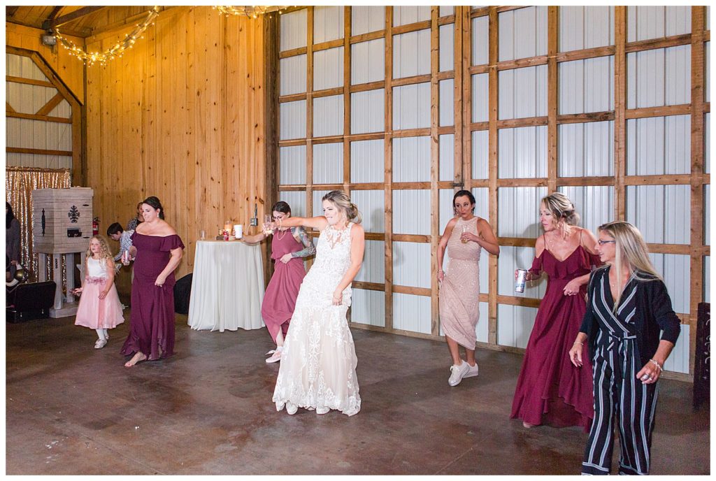 Bride and bridesmaids dancing at NC wedding in Mount Pleasant at the Farm at Brusharbor by Charlotte wedding photographer, Jacqueline Jones