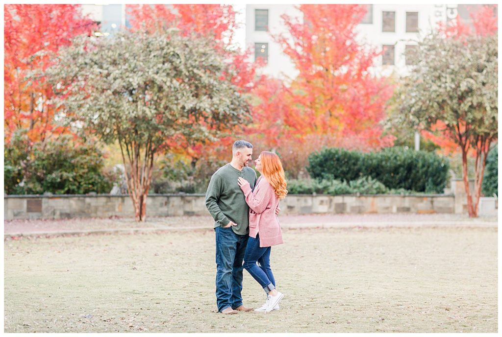 Engaged couple standing at the Romare Bearden Park in Charlotte, NC, by Charlotte engagement photographer, Jacqueline Jones