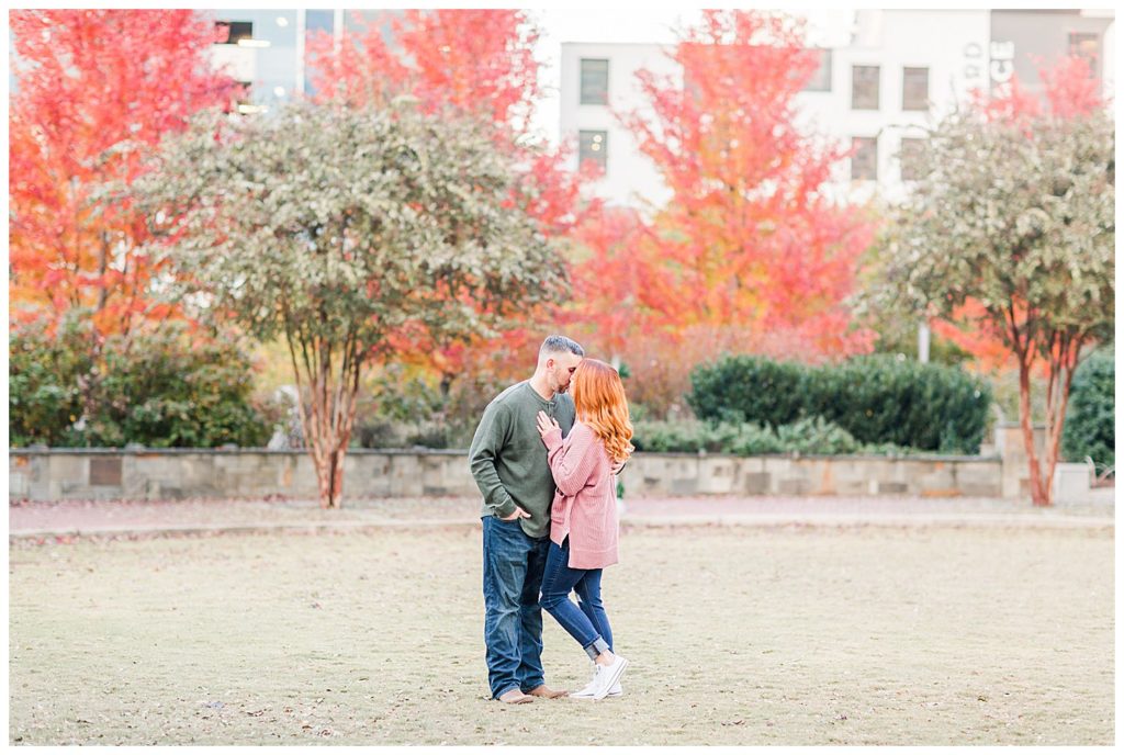 Engaged couple standing at the Romare Bearden Park in Charlotte, NC, by Charlotte engagement photographer, Jacqueline Jones