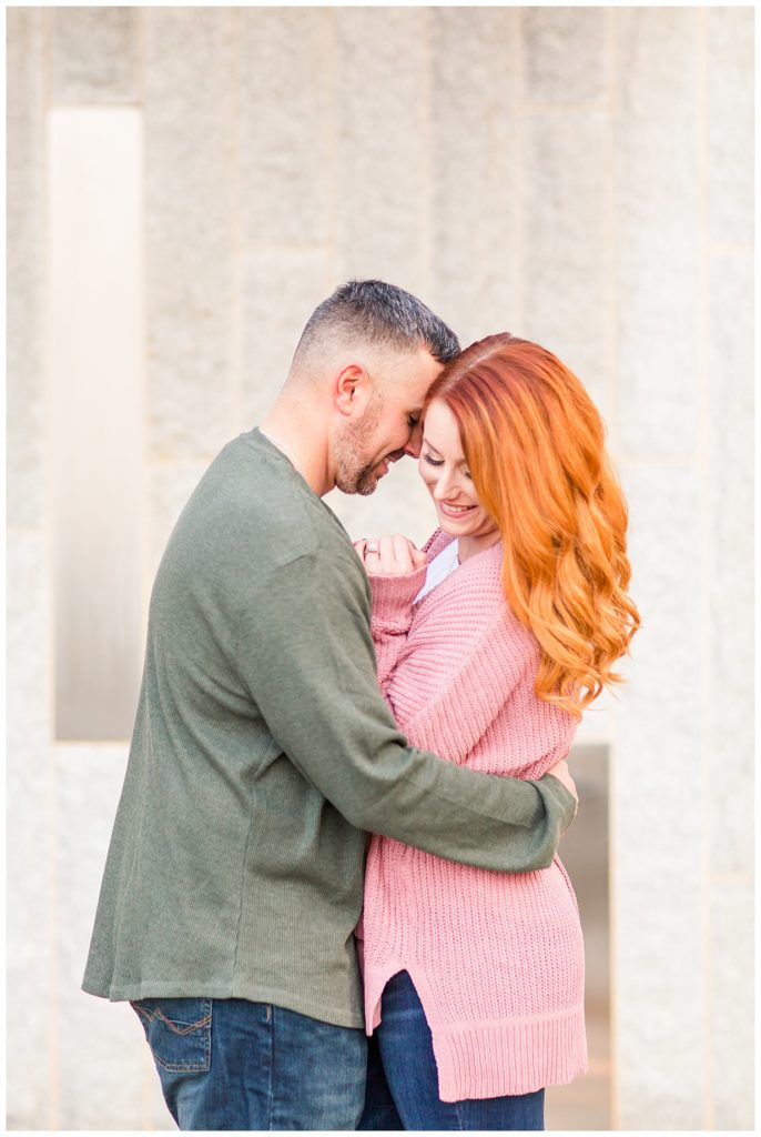 Engaged couple hugging at the Romare Bearden Park in Charlotte, NC, by Charlotte engagement photographer, Jacqueline Jones