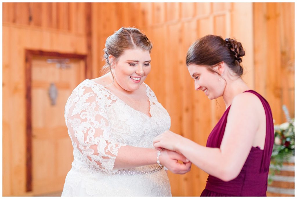 Bride and bridesmaid helping her at the Barn at Sandcastle Farm in Dallas, NC by Charlotte wedding photographer, Jacqueline Jones