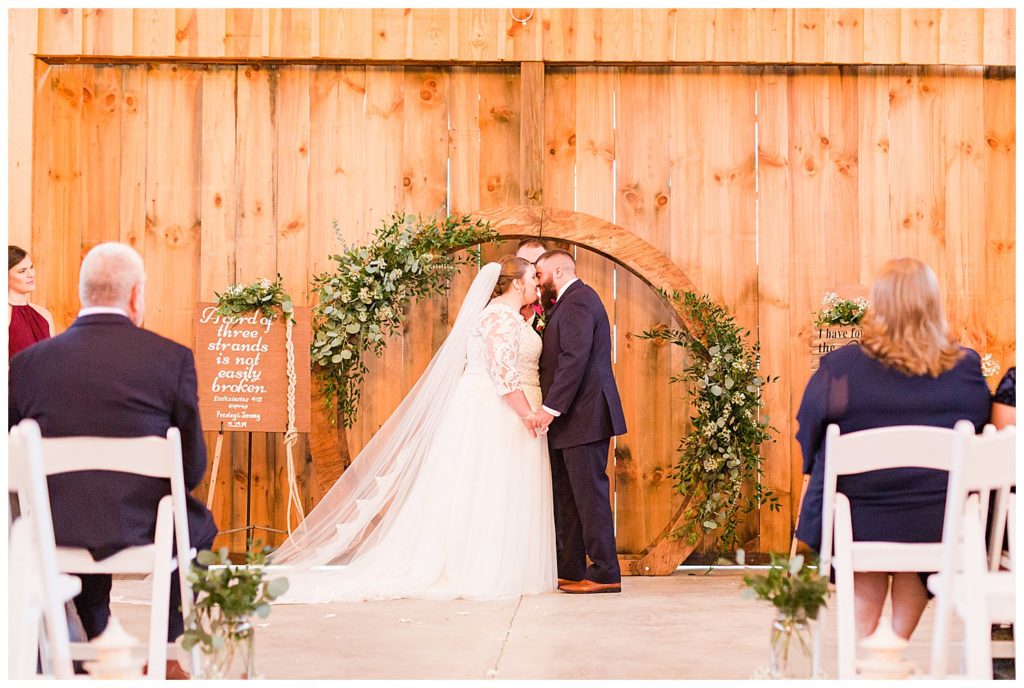 Bride and groom kissing at the alter at the Barn at Sandcastle Farm in Dallas, NC by Charlotte wedding photographer, Jacqueline Jones