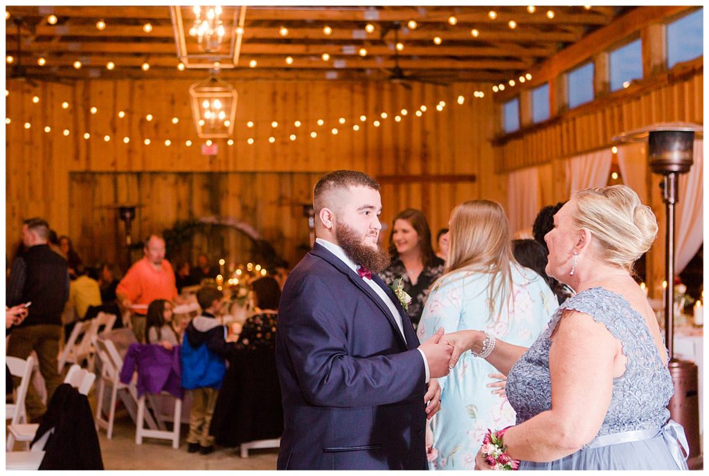 Groom speaking to wedding guest at the Barn at Sandcastle Farm in Dallas, NC by Charlotte wedding photographer, Jacqueline Jones