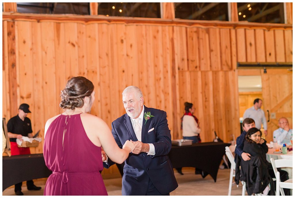 Father of bride speaking to bridesmaid at the Barn at Sandcastle Farm in Dallas, NC by Charlotte wedding photographer, Jacqueline Jones