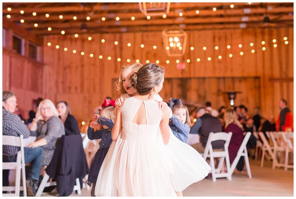 Flower girls dancing at the Barn at Sandcastle Farm in Dallas, NC by Charlotte wedding photographer, Jacqueline Jones