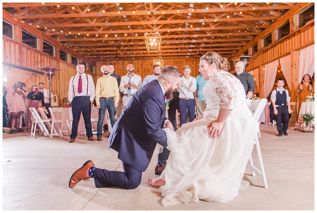 Groom removing bride’s garter at the Barn at Sandcastle Farm in Dallas, NC by Charlotte wedding photographer, Jacqueline Jones