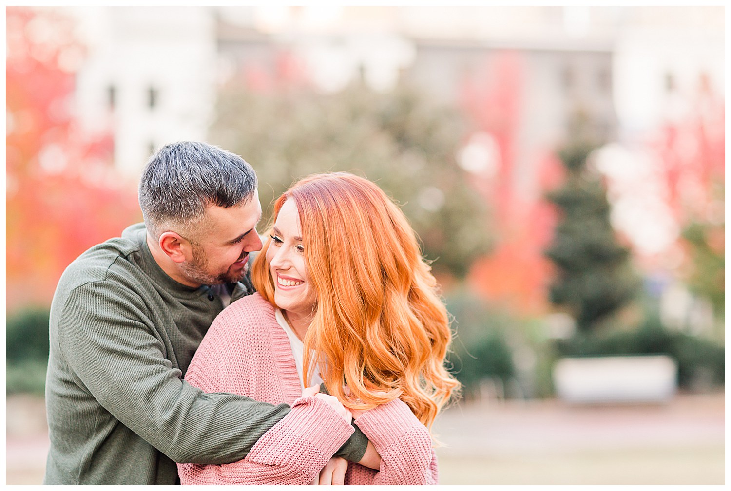 Engaged couple smiling at each other at the Romare Bearden Park in Charlotte, NC, by Charlotte engagement photographer, Jacqueline Jones